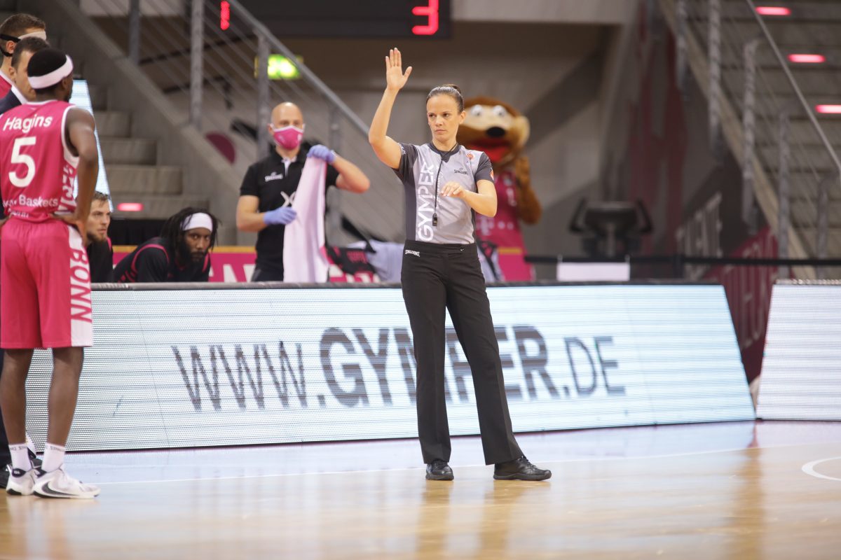 BBL-Schiedsrichterin Anne Panther vor einer GYMPER-Werbebande.