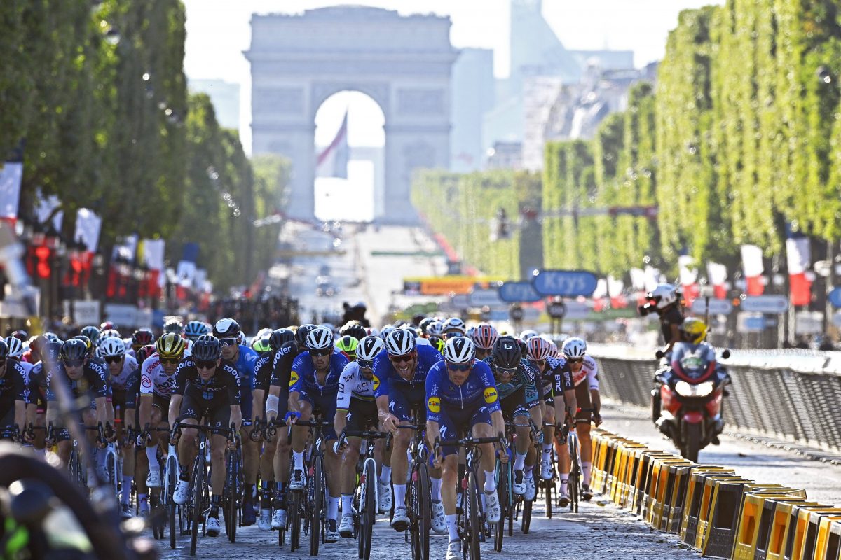 Radsportler auf der Avenue des Champs Élysées in Paris, im Hintergrund der Triumphbogen.